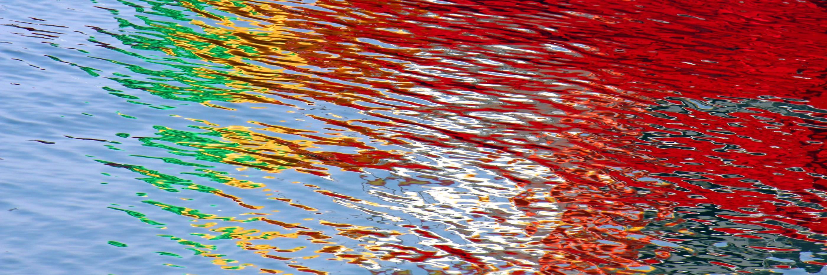 Wasseroberfläche bunt gefärbt durch Lichtspiegelung