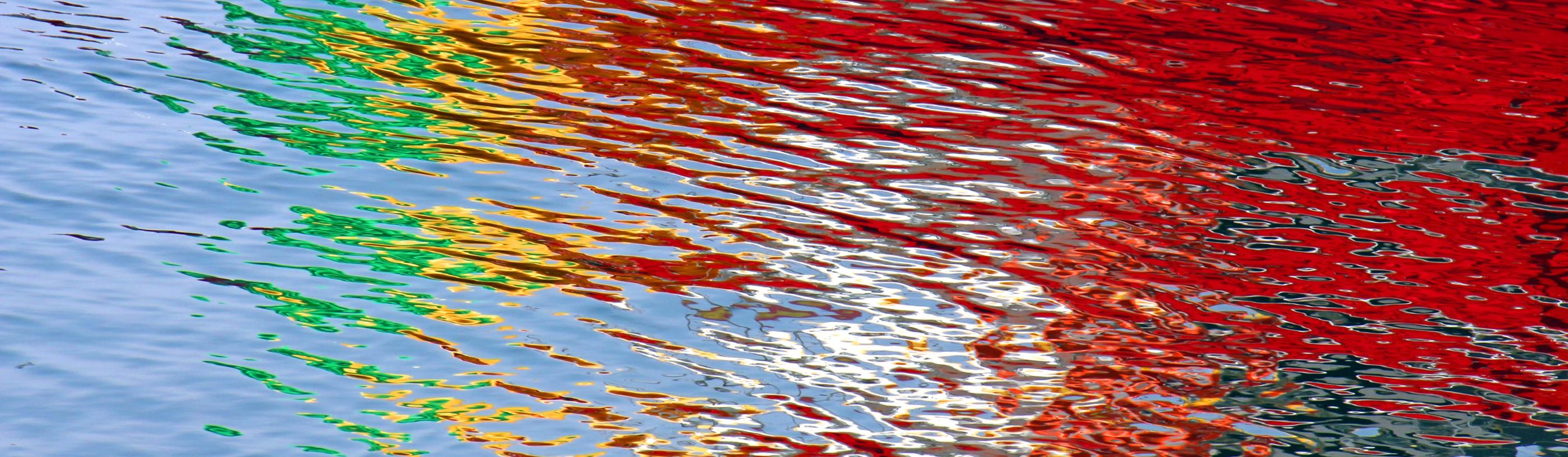 Wasseroberfläche bunt gefärbt durch Lichtspiegelung