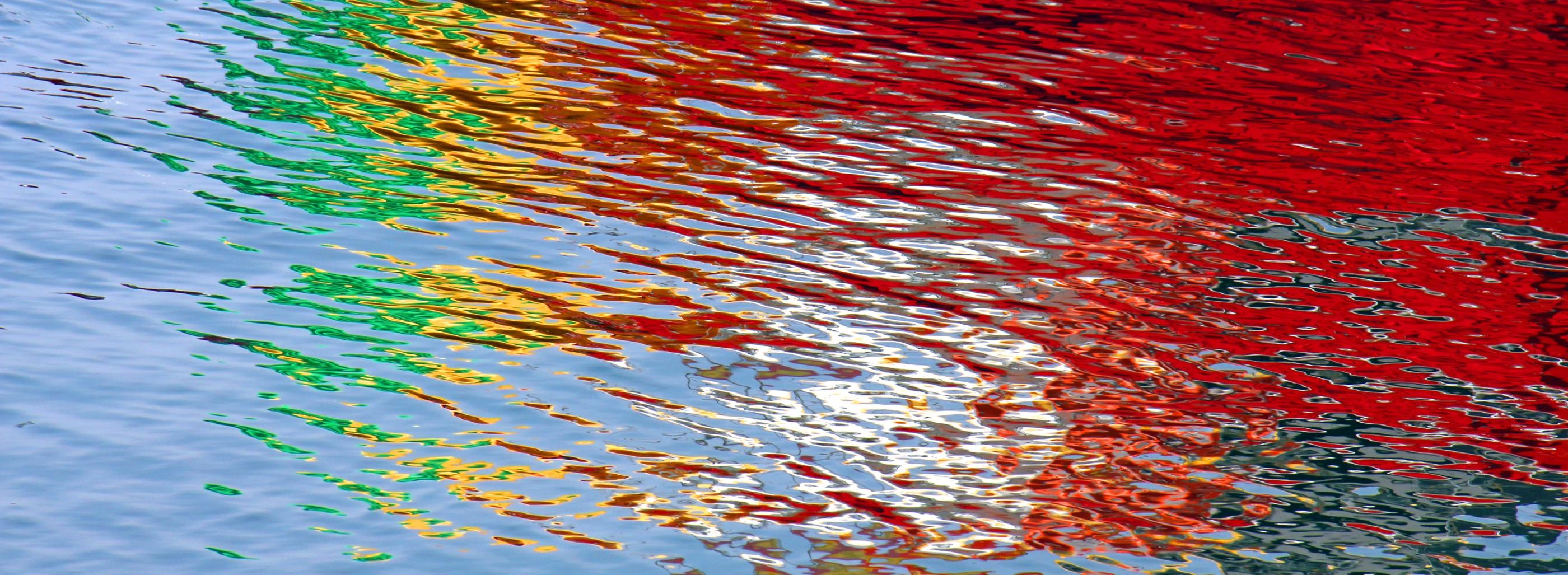 Wasseroberfläche bunt gefärbt durch Lichtspiegelung