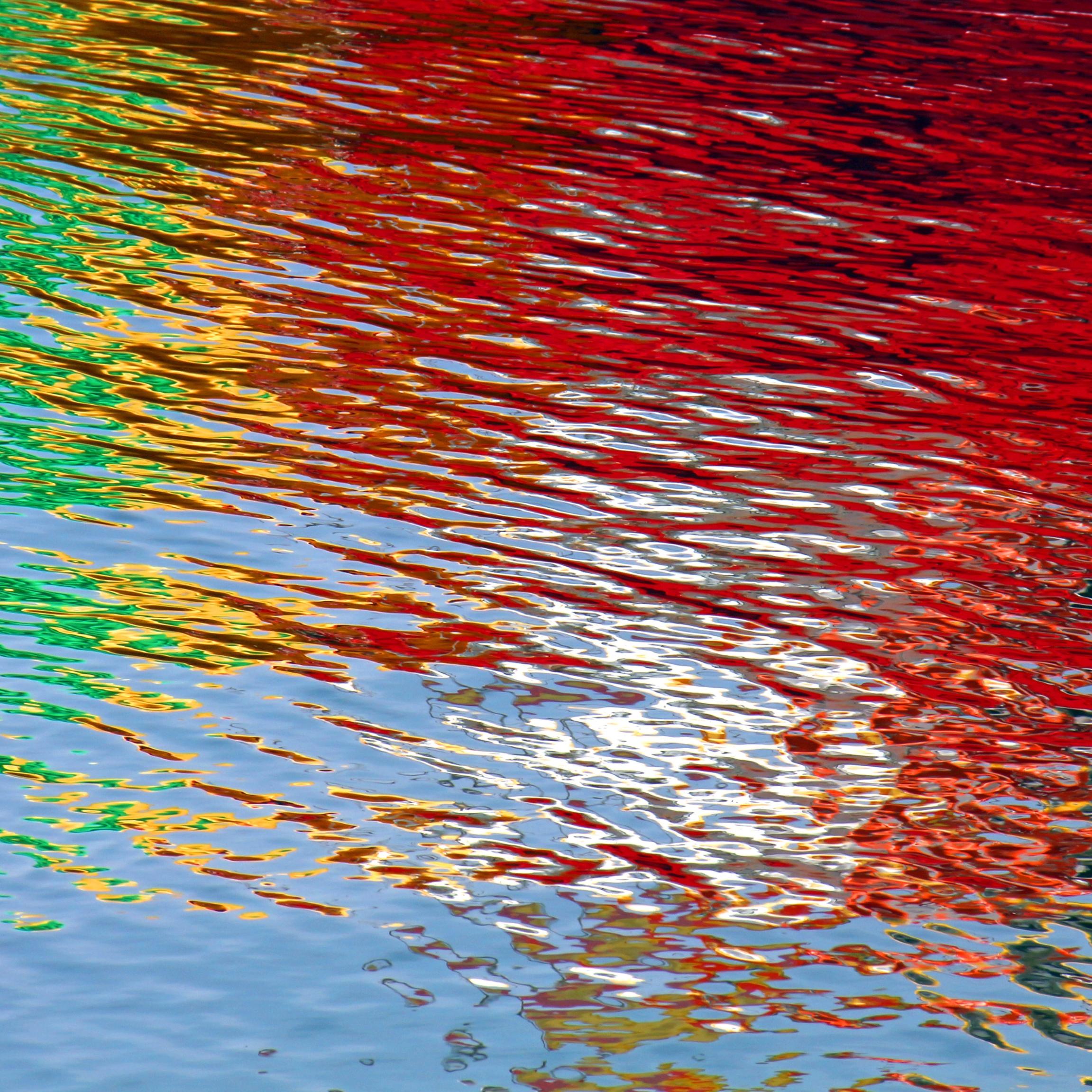 Wasseroberfläche bunt gefärbt durch Lichtspiegelung