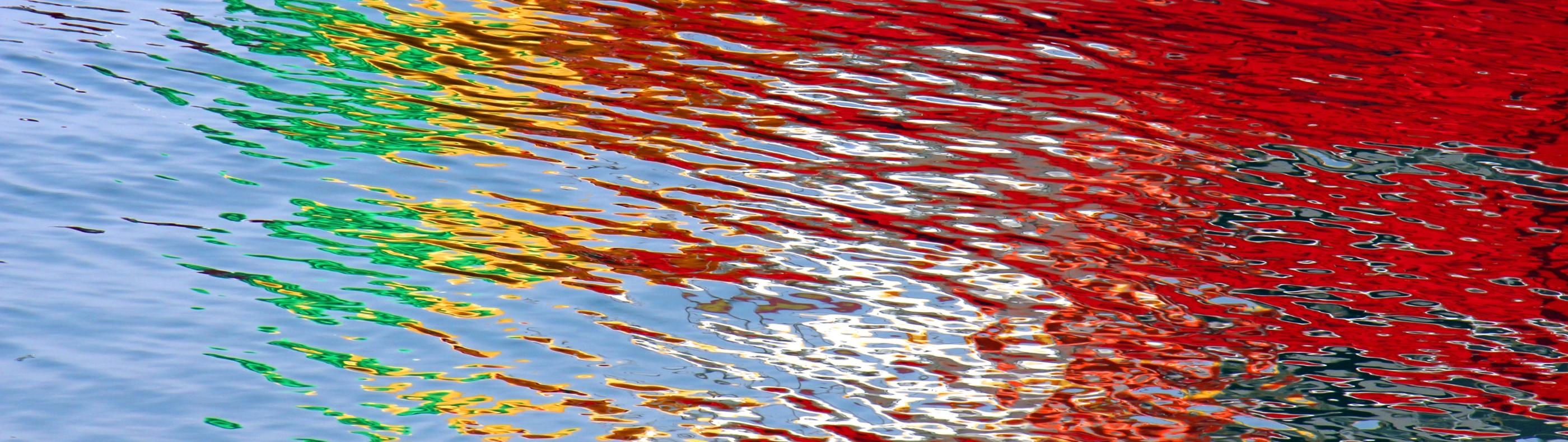Wasseroberfläche bunt gefärbt durch Lichtspiegelung