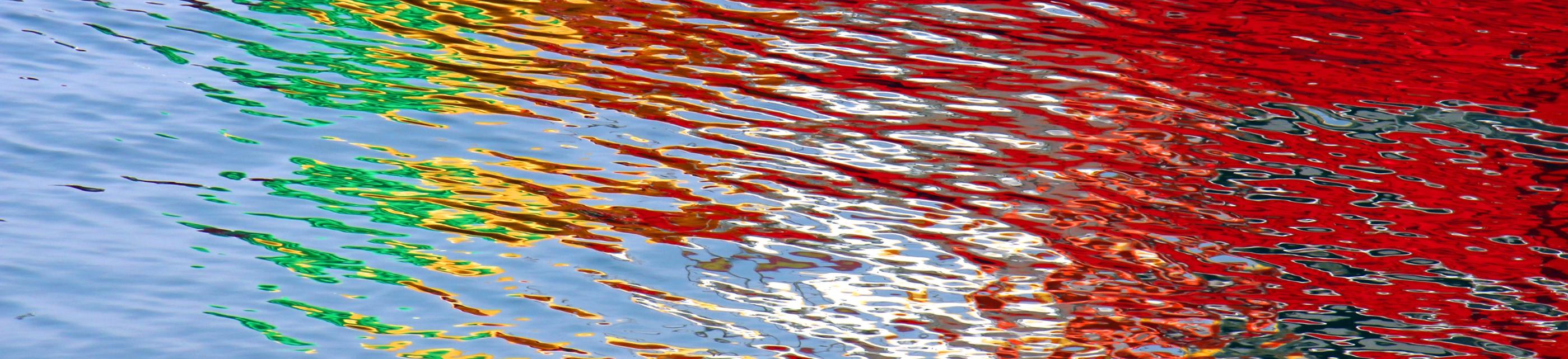 Wasseroberfläche bunt gefärbt durch Lichtspiegelung