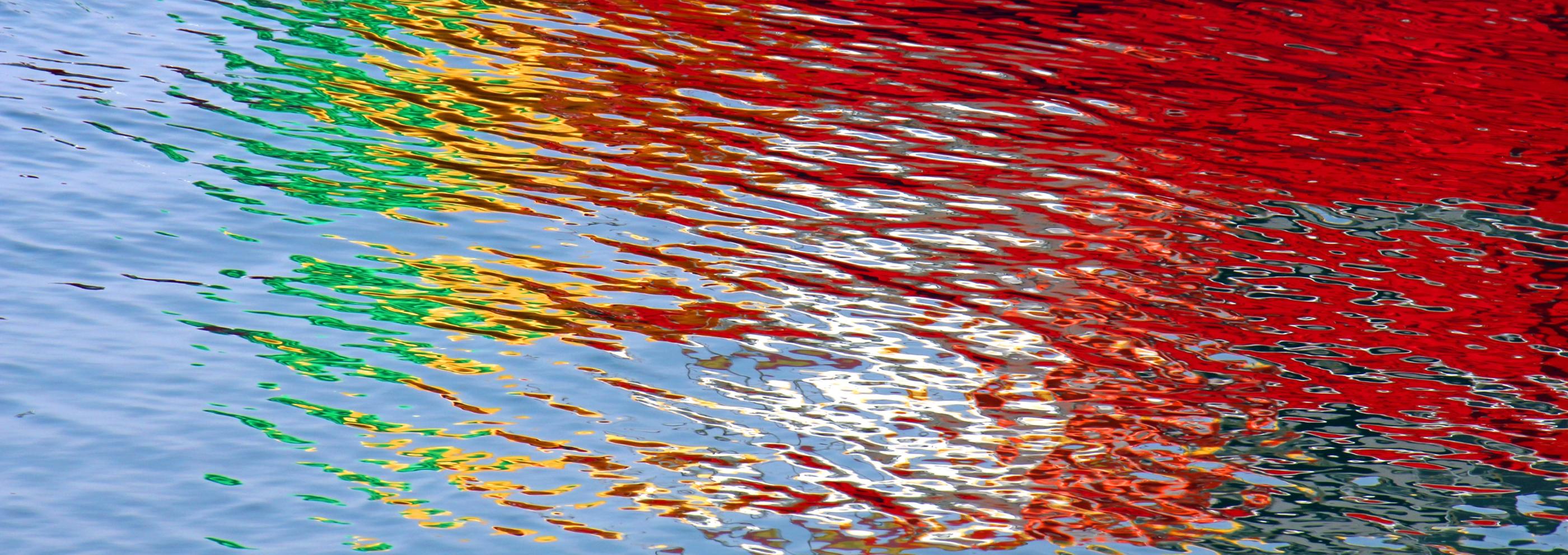 Wasseroberfläche bunt gefärbt durch Lichtspiegelung
