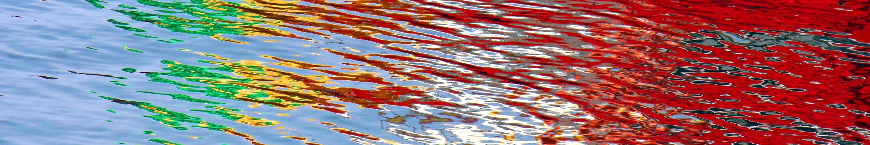 Wasseroberfläche bunt gefärbt durch Lichtspiegelung