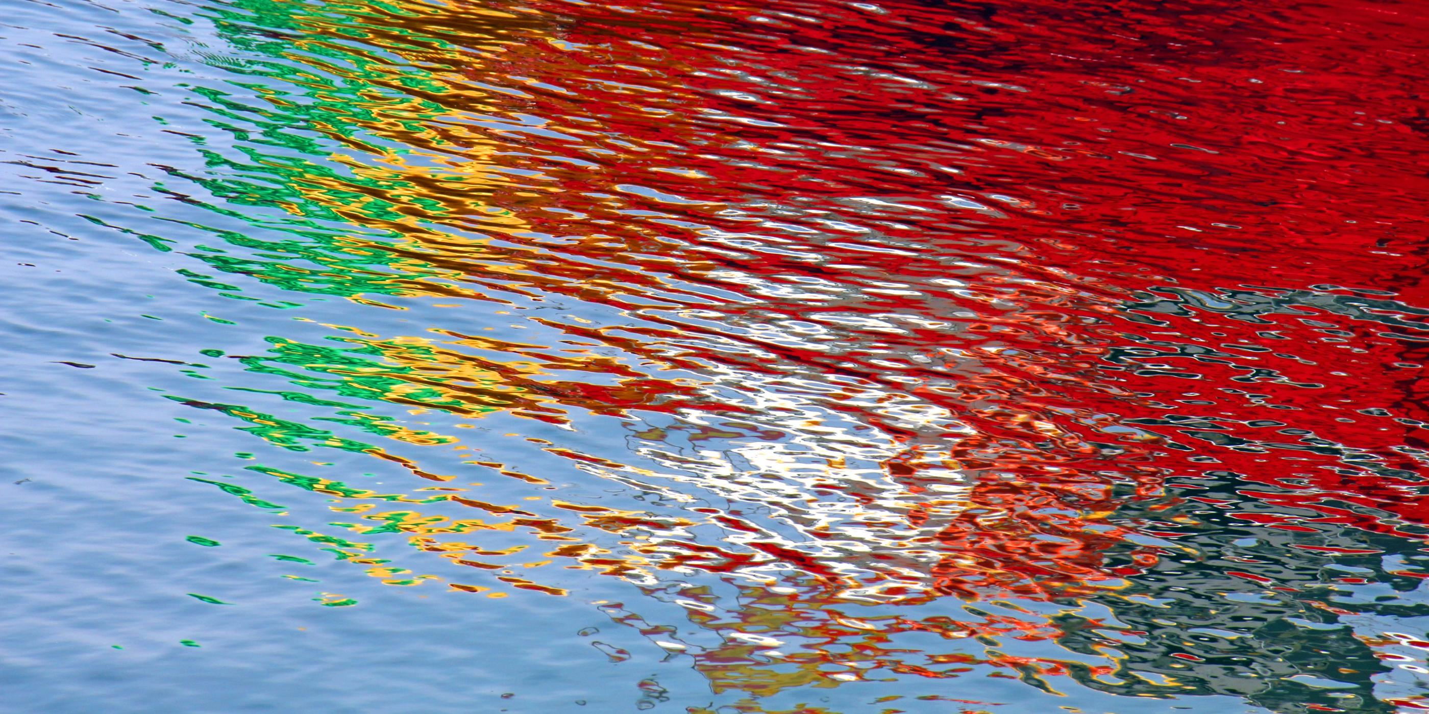 Wasseroberfläche bunt gefärbt durch Lichtspiegelung