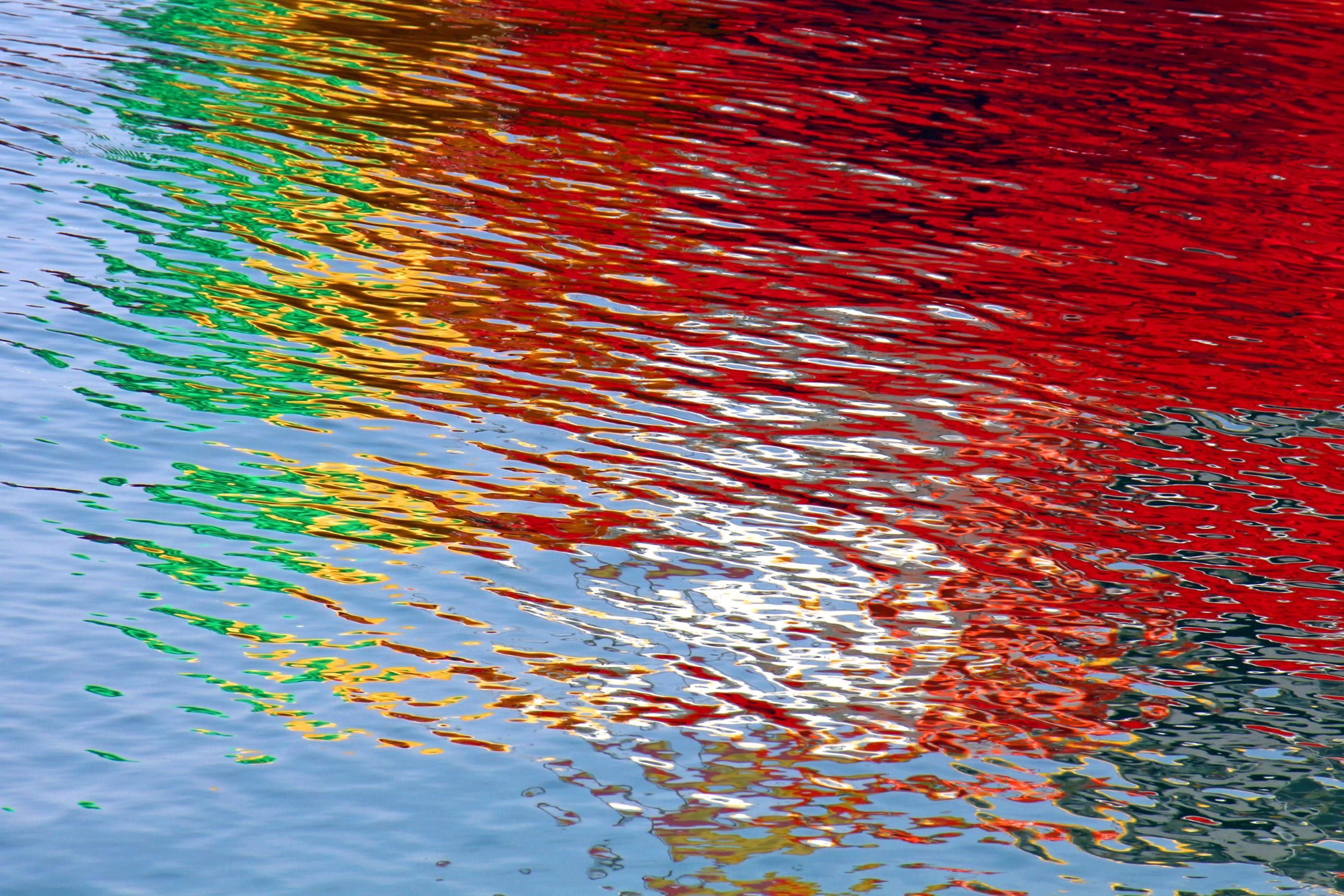 Wasseroberfläche bunt gefärbt durch Lichtspiegelung